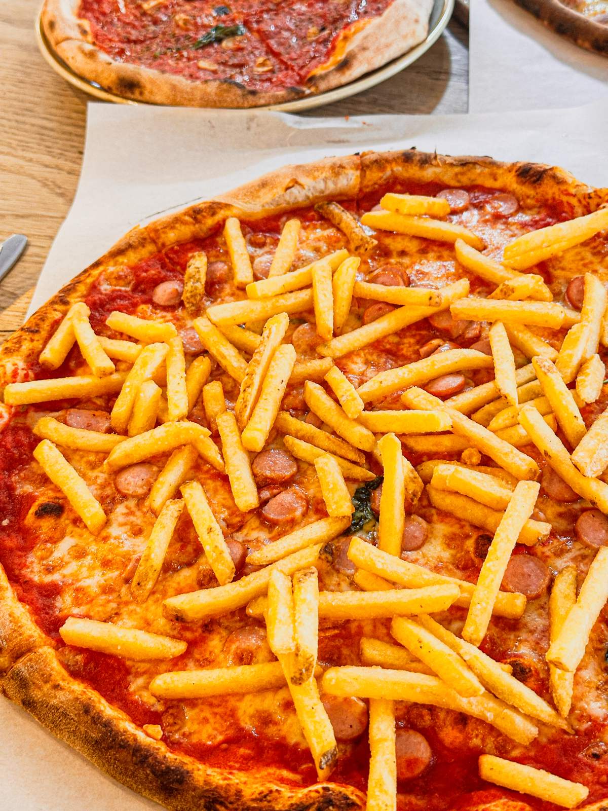 Pizza topped with chips and sliced sausage at Giovanni's Caffè and Pizzeria on Burleigh Street, Cambridge